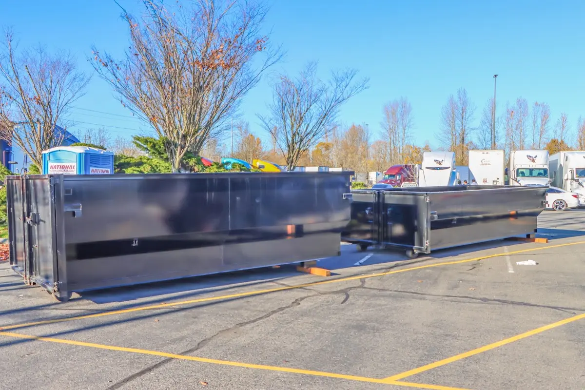 Professional dumpster rental service with roll-off container on residential driveway in DeWitt